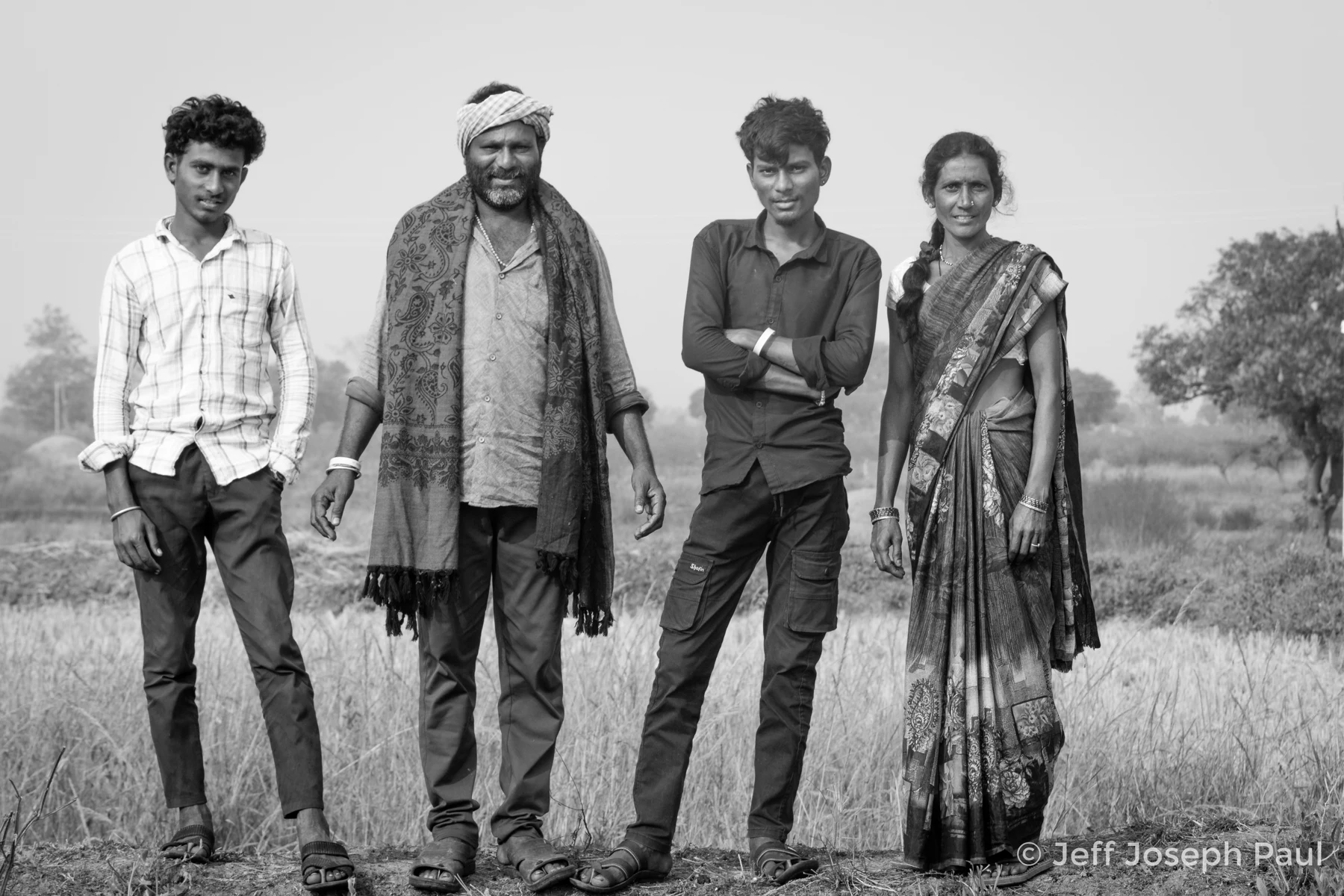 Members of a family stand in a field.