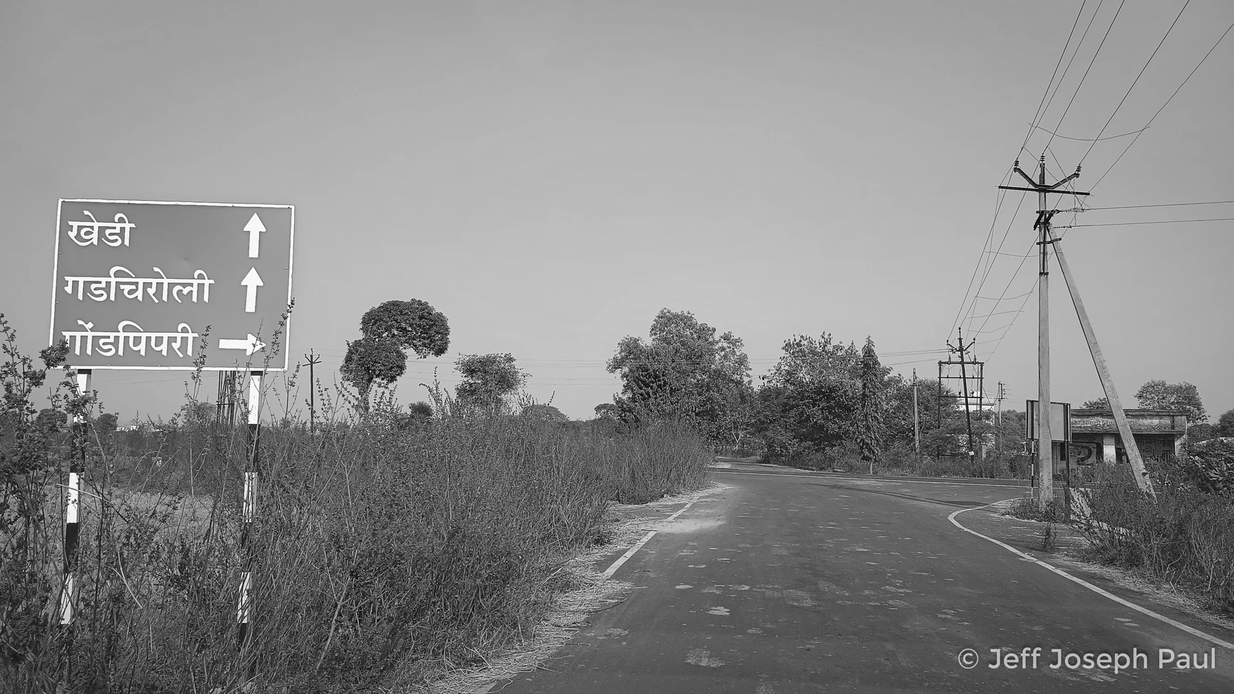 A sign beside a rural road in Chandrapur.