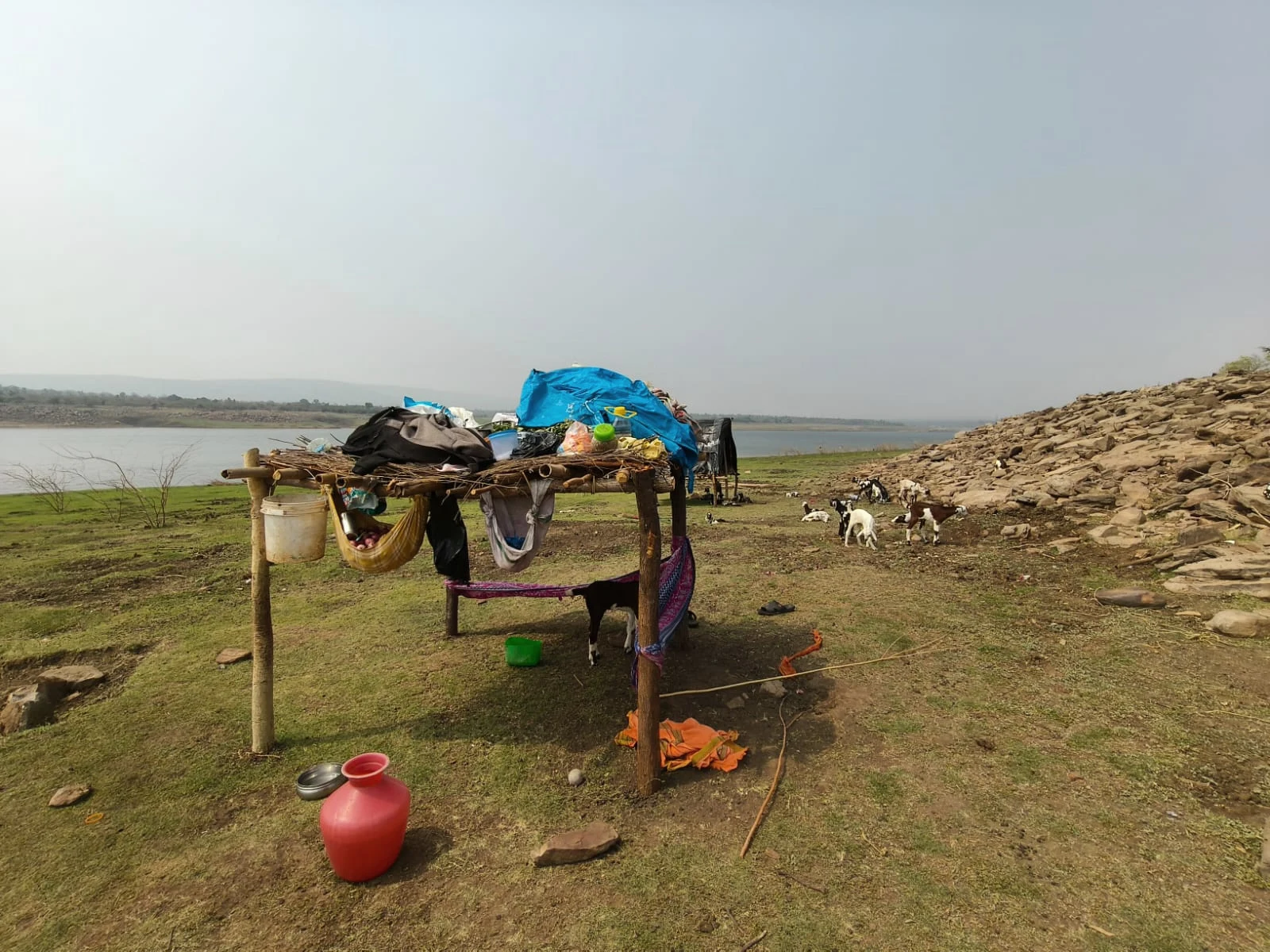 Water vessels beside a temporary dwelling.