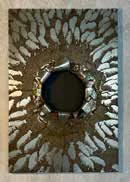 An etched metal plate with a flock of sheep surrounding a central void.